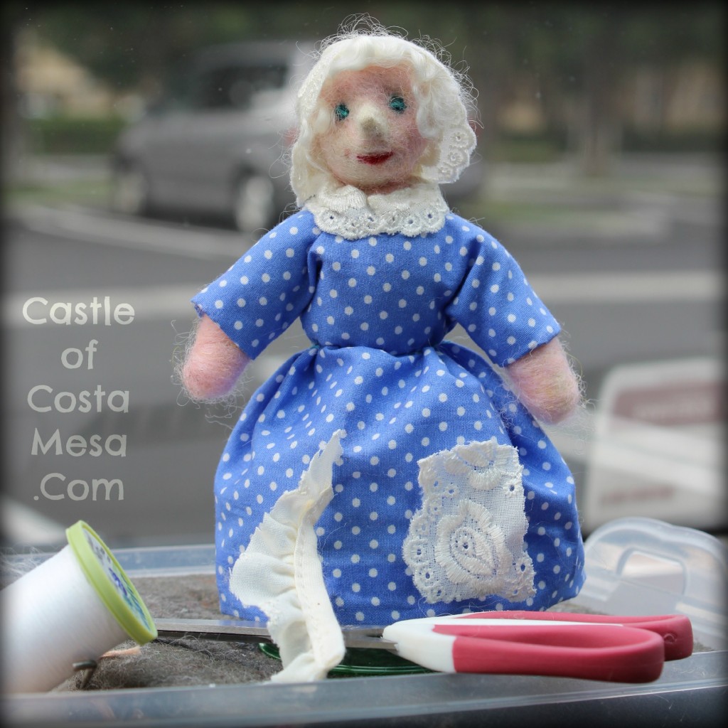 Old woman with bonnet being handcrafted on dashboard at Chinese School parking lot