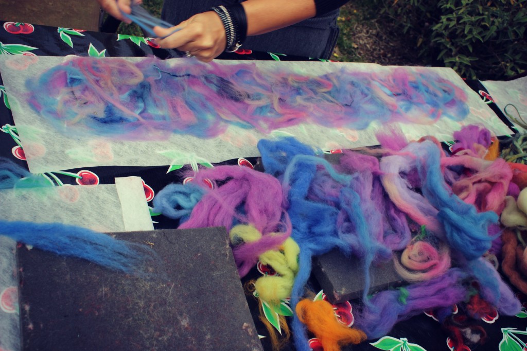 130123 Renuka laying down thin strips of colored roving on her Artfelt paper