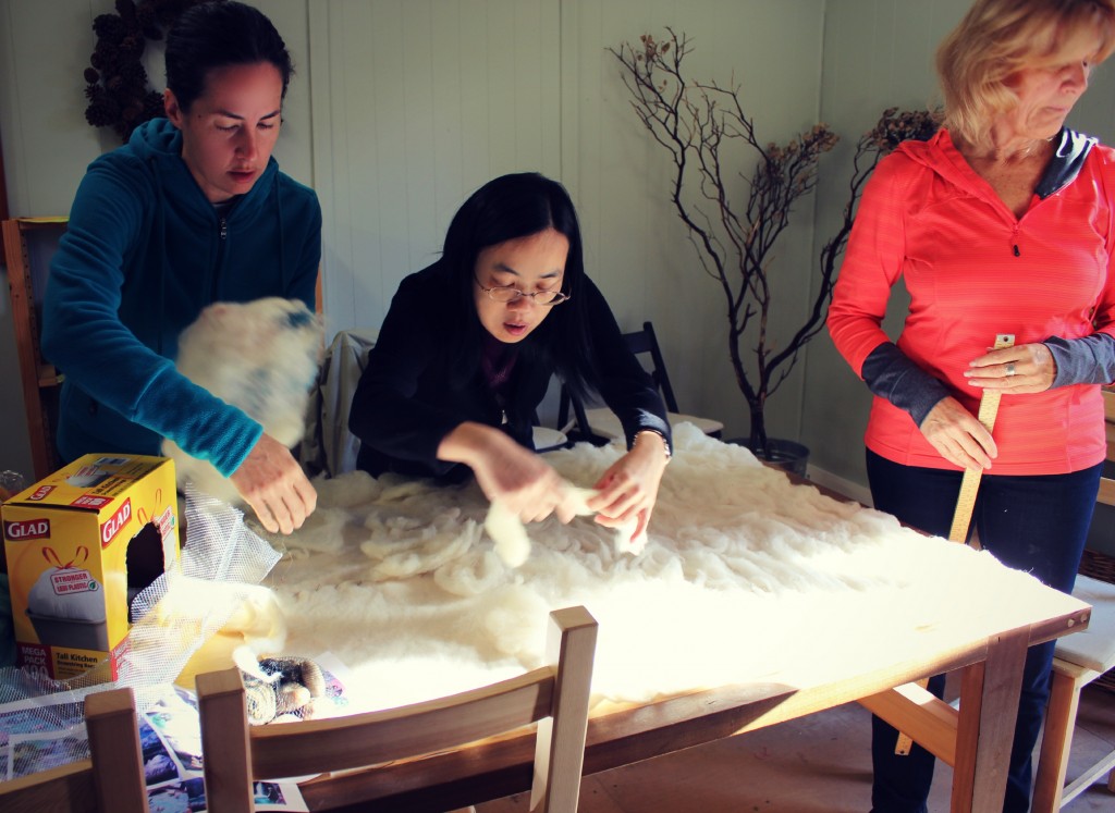 130130 Rebecca and Josephine applying white roving to pat pre-felted wool base for playscape.