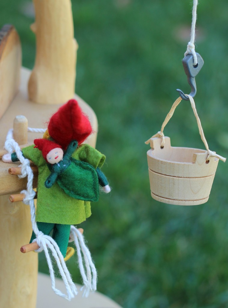 130226 Miniature gnome mommy with gnome baby on her back climbing a rope ladder up her magic fairy tree house