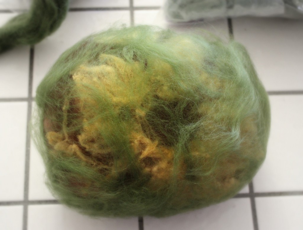 139=0315 adding thin flat layers of green roving to wet felted bunny home