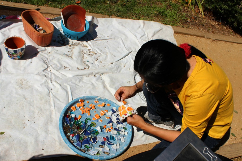 130410 Josephine carefully selecting broken tiles to arrange on her mosaic miniature flower pot