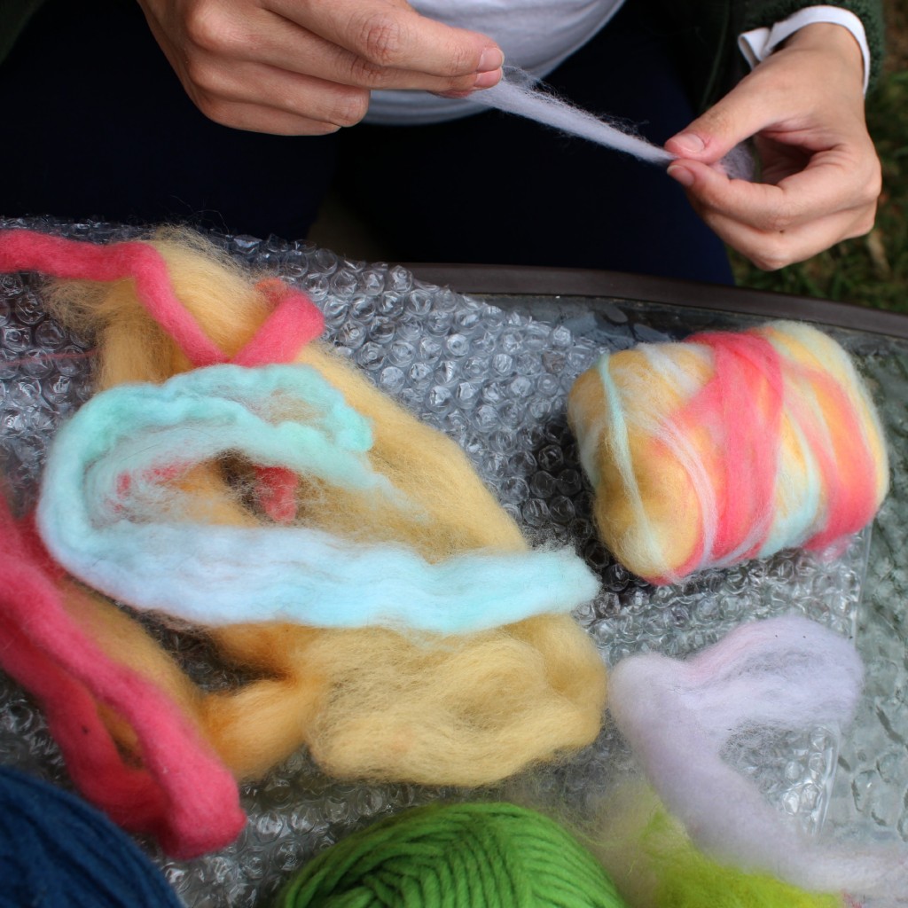 130501 Kimmy laying colorful wool roving on wet-felted soap project
