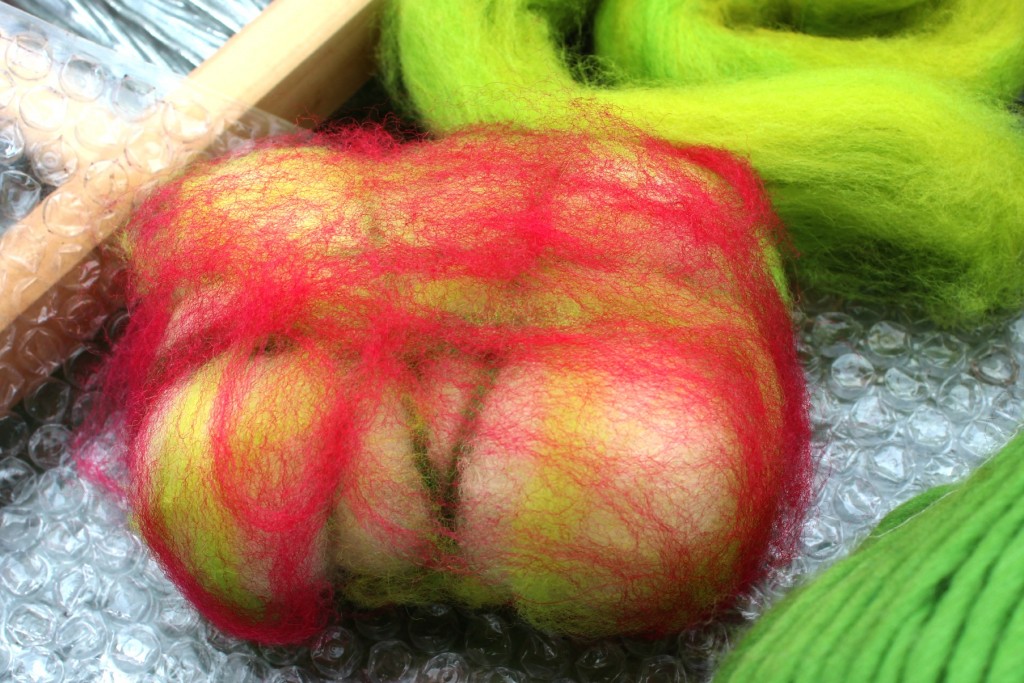 130501 soap wrapped in thin layers of chartreuse and rose red corriedale wool top roving and lime green pencil roving