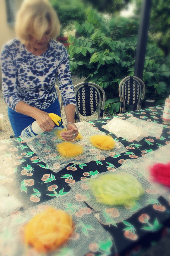130918 Christine spraying hot soapy water on thin layers of wool roving on bubble wrap