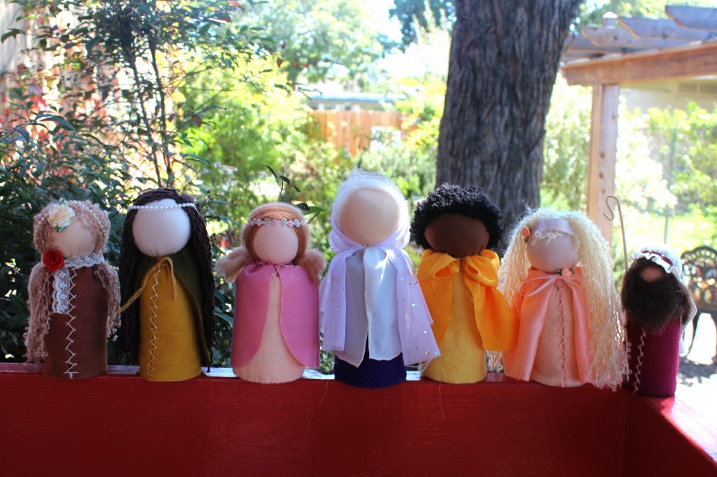 131001 7 table top puppets lined up on railing by Company of Angels store