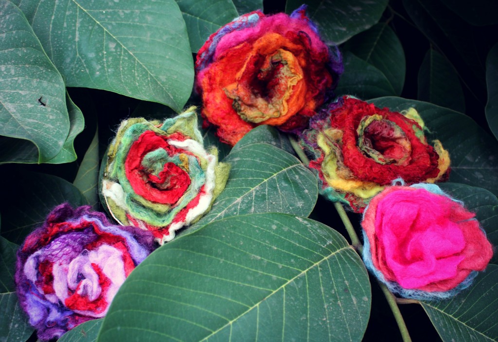 131007 5 wet-felted flowers embellished with mawata silk hankies made by craft group sitting in cherimoya tree