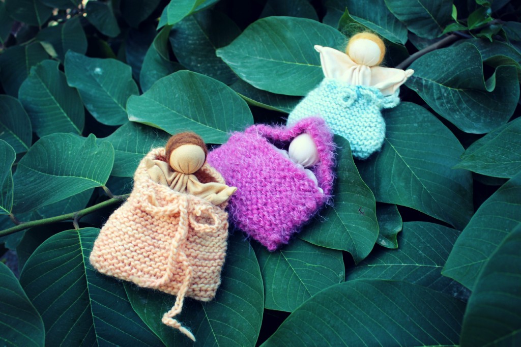 131029 3 Simple Waldorf Style Handmade hanky baby dolls in knitted blanket bags on cherimoya tree.