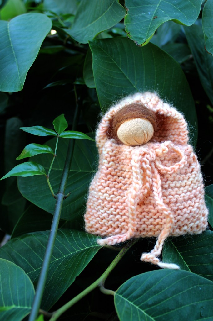 131029 Josephine's handmade simple Waldorf baby hanky doll in a knitted blanket bag on the cherimoya tree