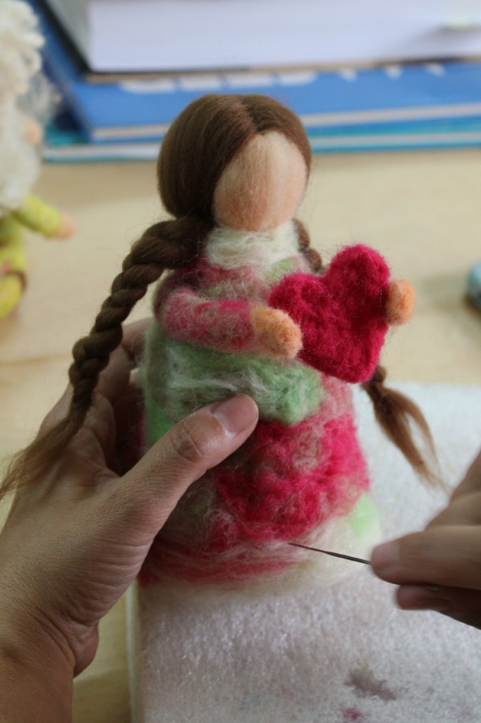 140121 Lisa needle-felting a brown haired guardian doll of love with two long brunette braids