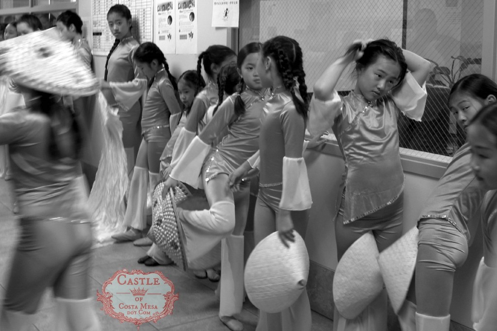 140102 chinese folk dancers lining up bored waiting for stage showtime girl twirling tying braid hair