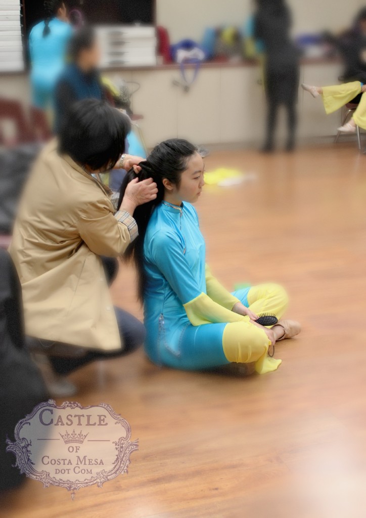 140202 Mother tying teenage daughter's hair for folk dancing