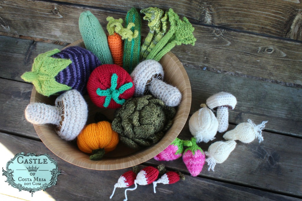 140310 Knitted and Crocheted Stone Soup vegetables and ingredients on bench under magnolia tree with logo