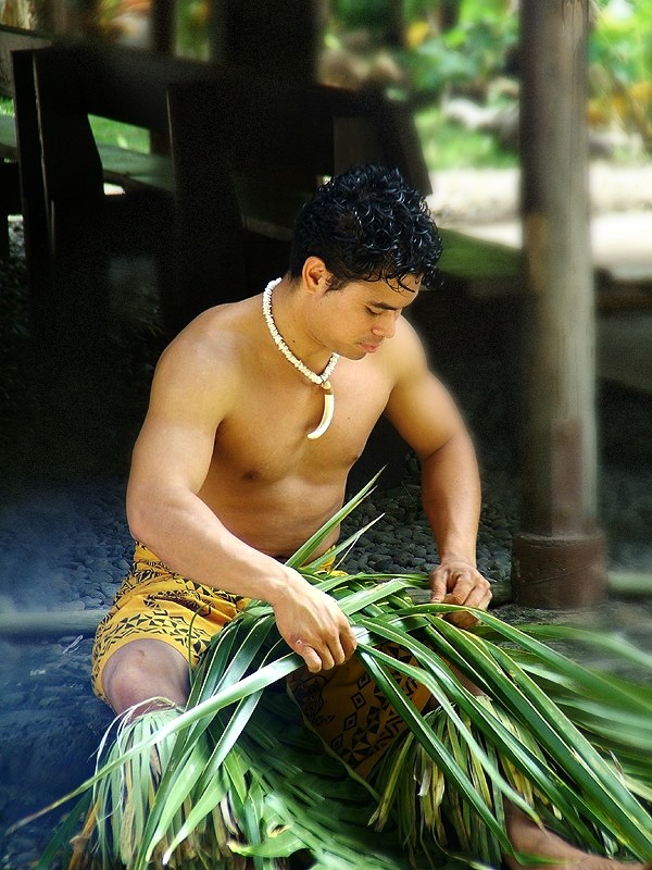 Samoan Man weaving coconut leaf basket for food from his Umu