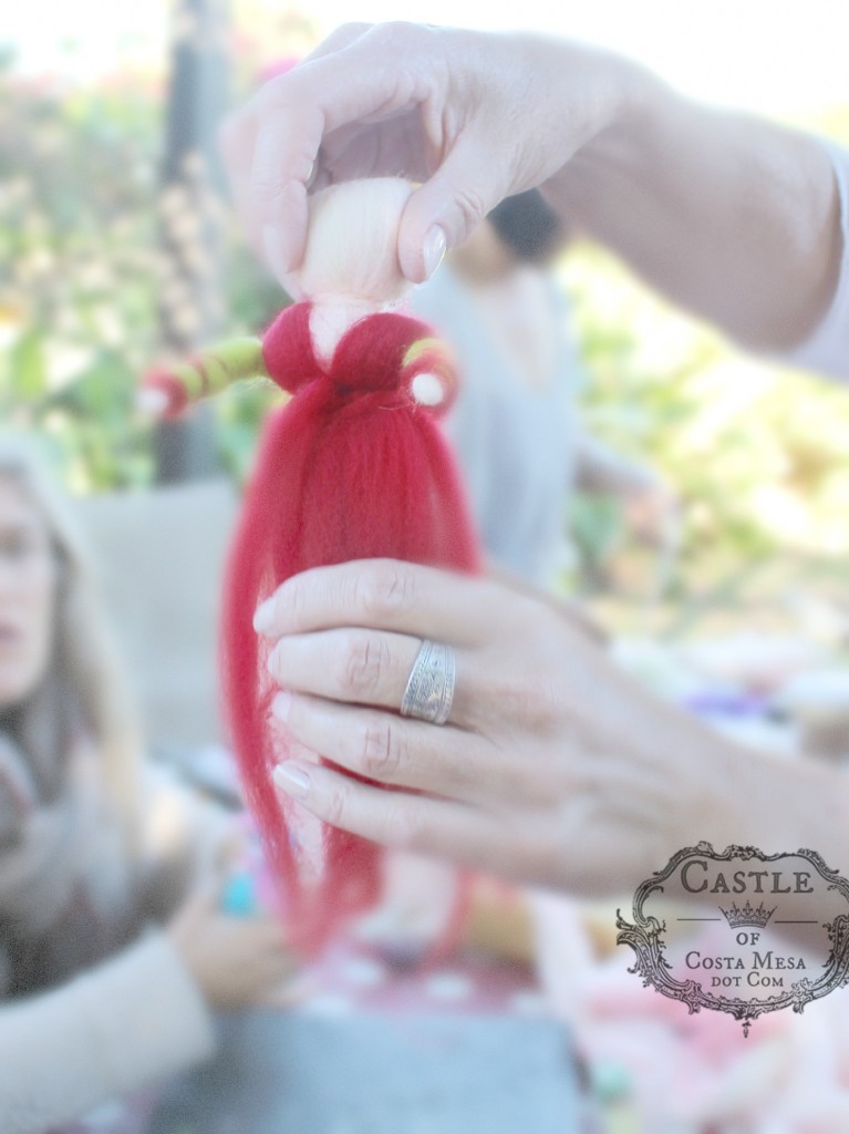 141117 Christine adding red robe and sash to her fairy doll.