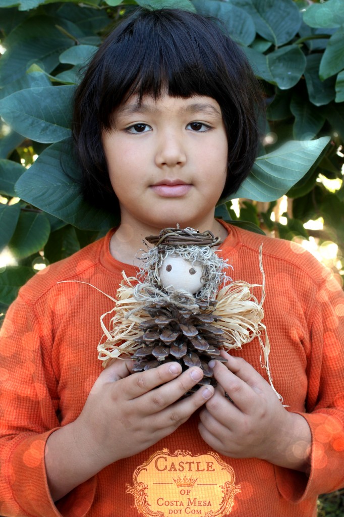 141208 Adrian and his handmade Winter Pine Cone Angel with straw wings.